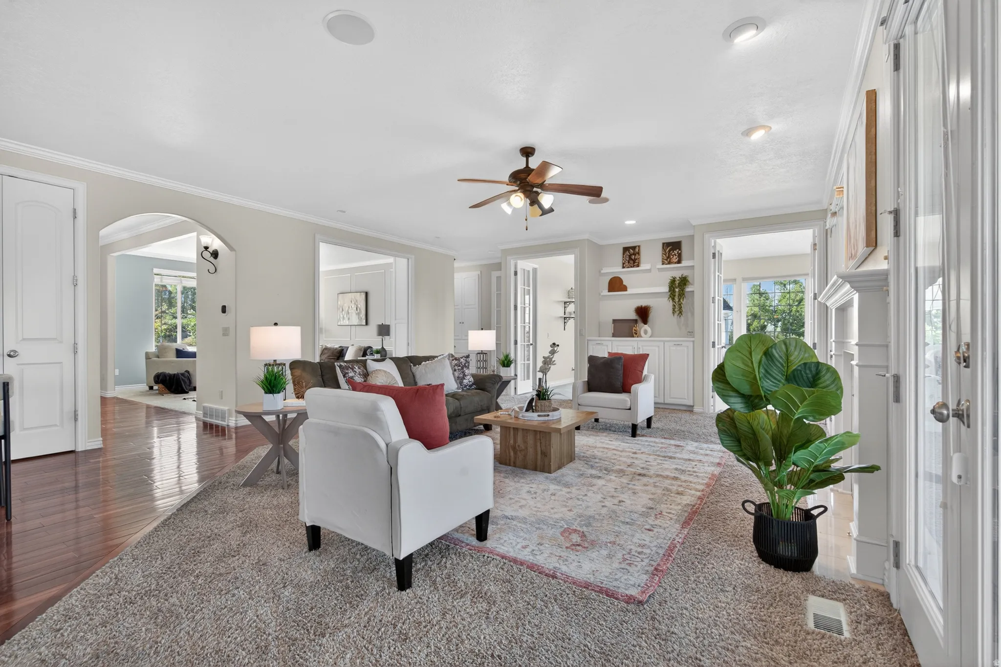 Living area featuring a ceiling fan, recessed lighting, and a combination of carpet and wood-finish flooring