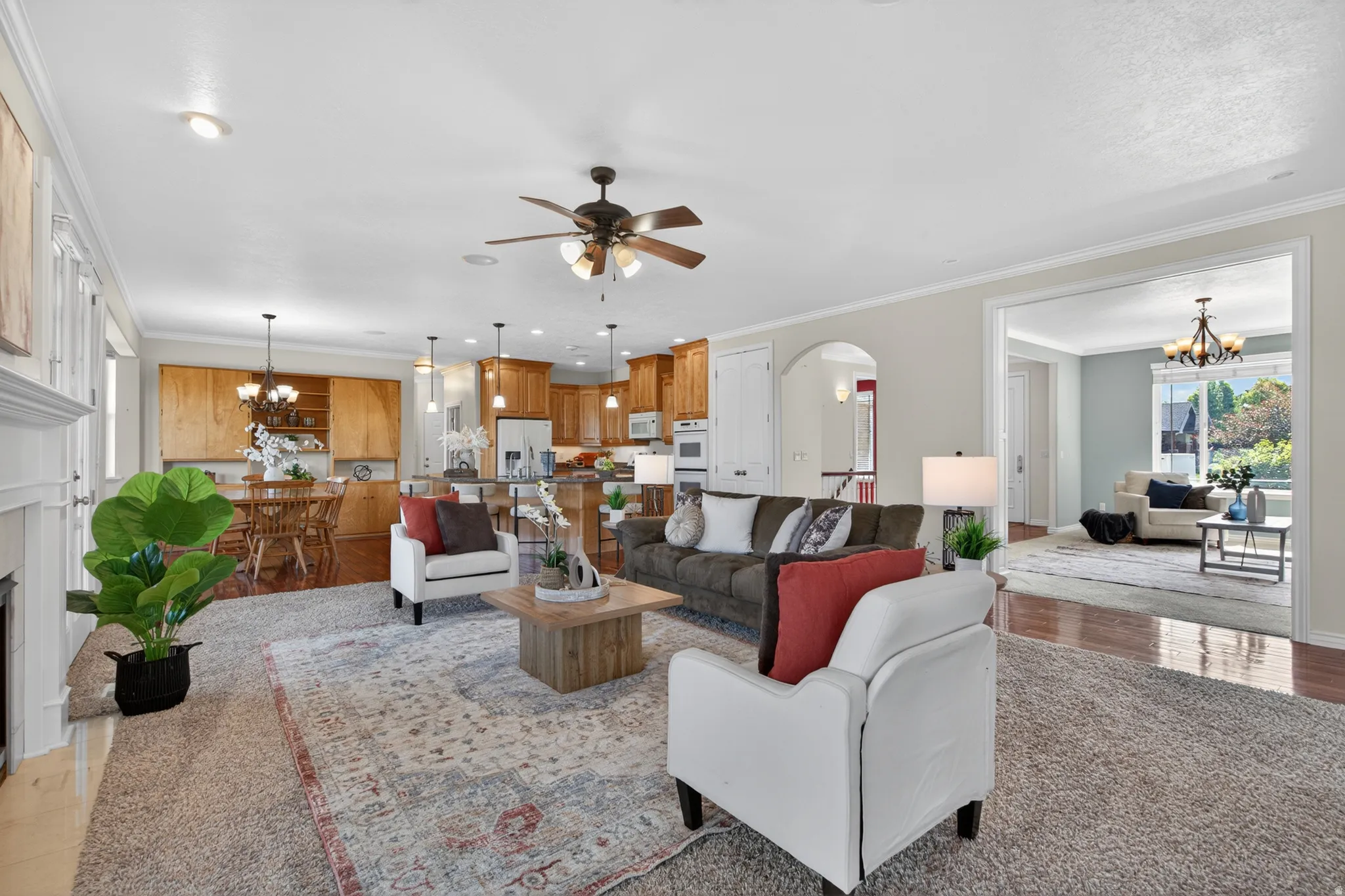 Spacious living area featuring light-toned walls and crown molding