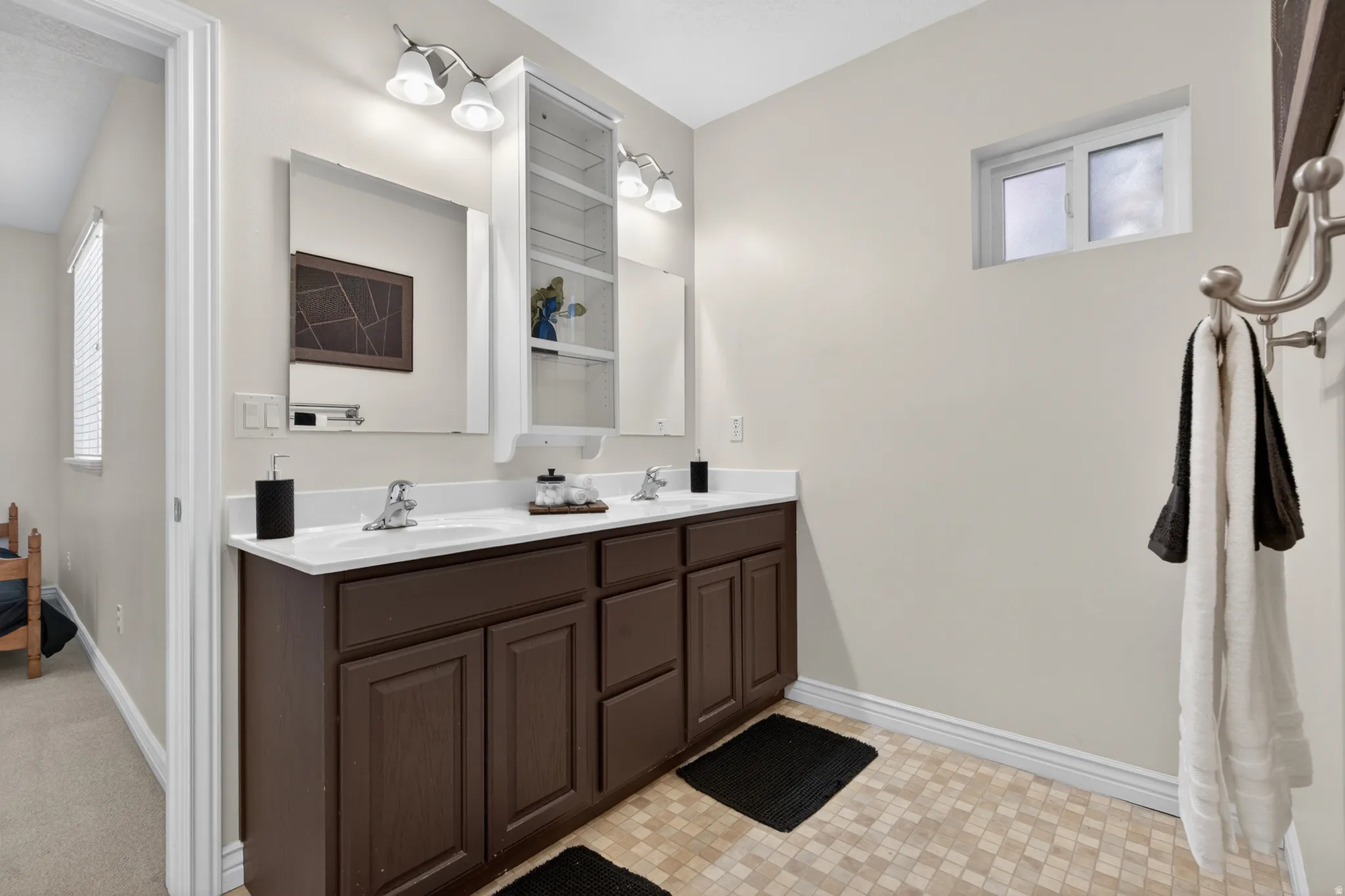 Dual vanity with brown cabinetry, white countertops, and integrated sinks