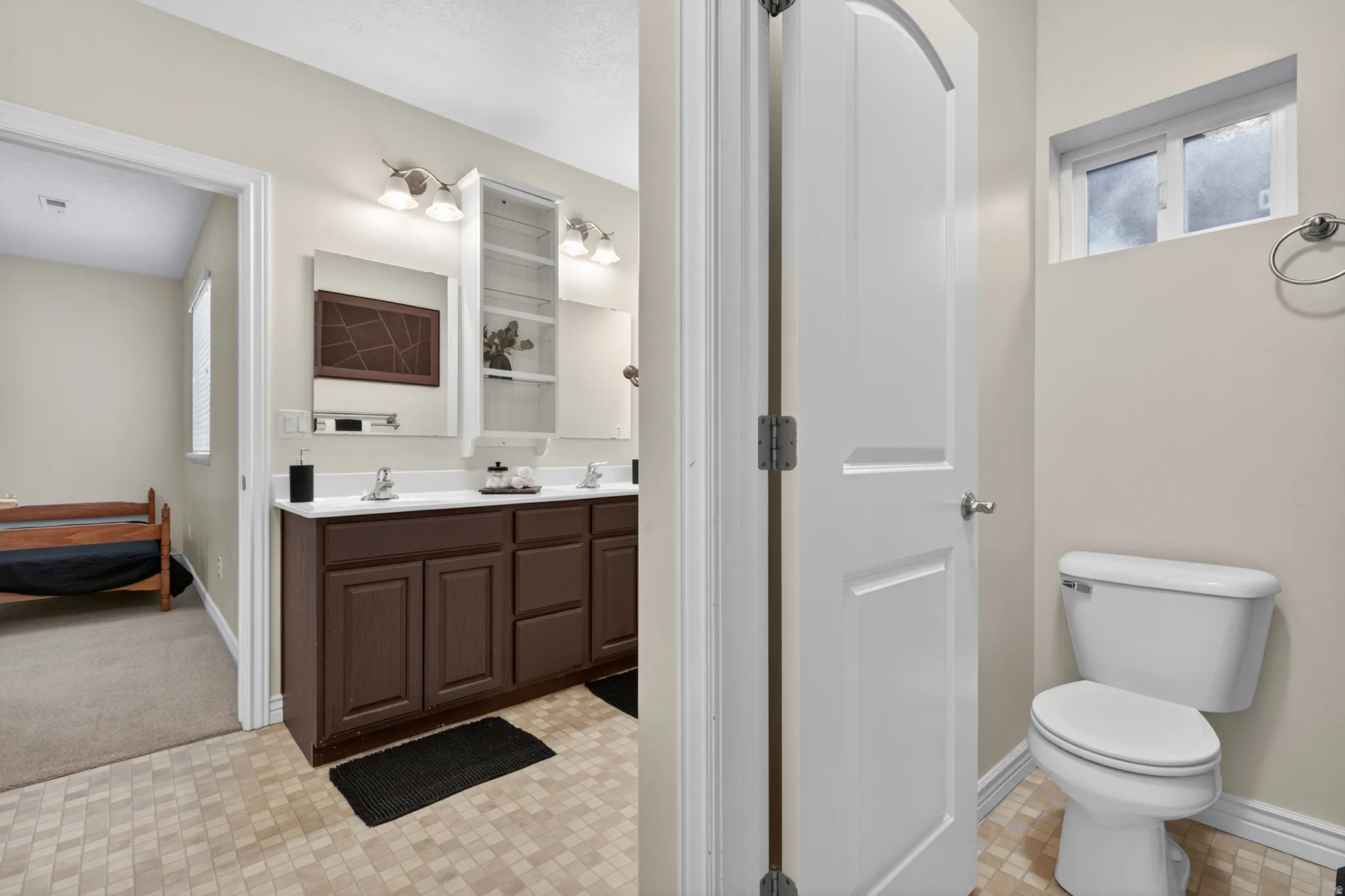 Bathroom featuring a dual vanity with a white countertop and dark wood-finish cabinetry