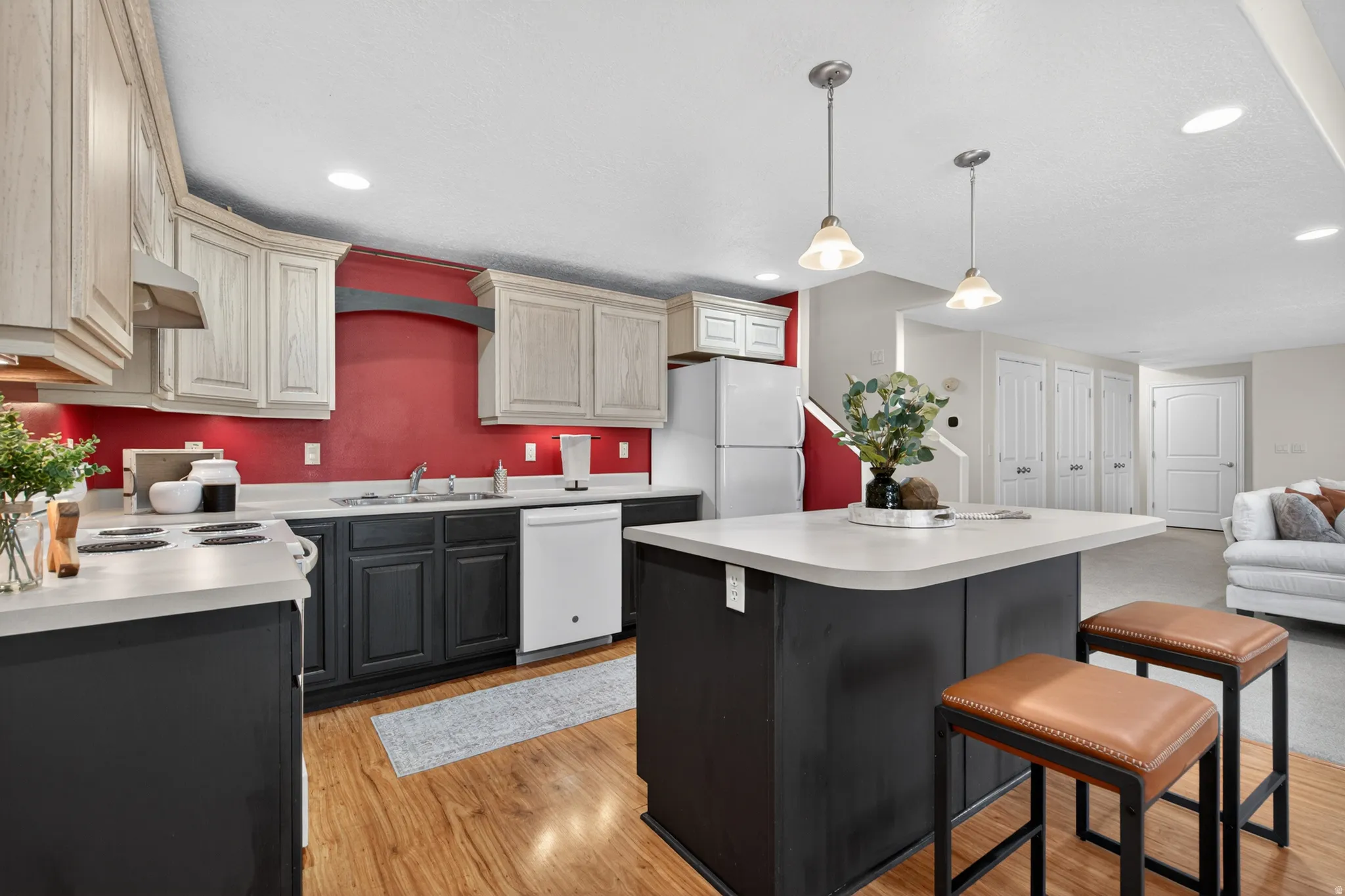 Kitchen featuring wood-finish flooring, white countertops, and dual-toned cabinetry