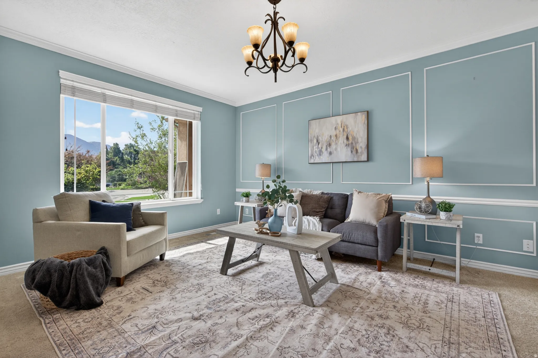 Spacious room featuring a large window, decorative wall molding, crown molding, and a five-light chandelier