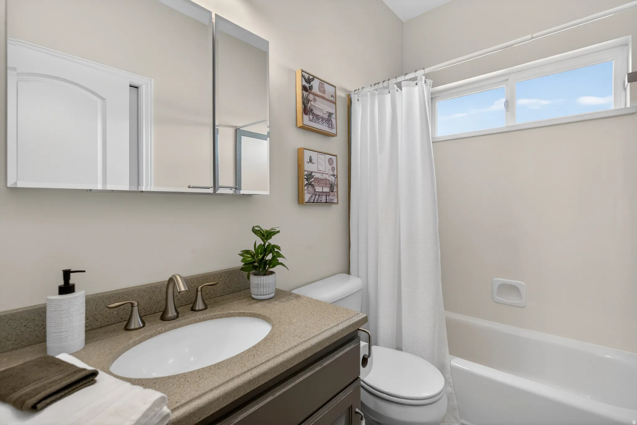 Bathroom featuring a vanity with a light speckled countertop, an undermount sink, and a brushed nickel faucet