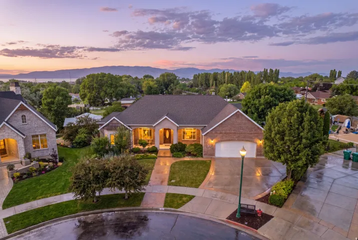 Traditional-style home featuring a brick and stone exterior, a two-car garage, and a covered front entry