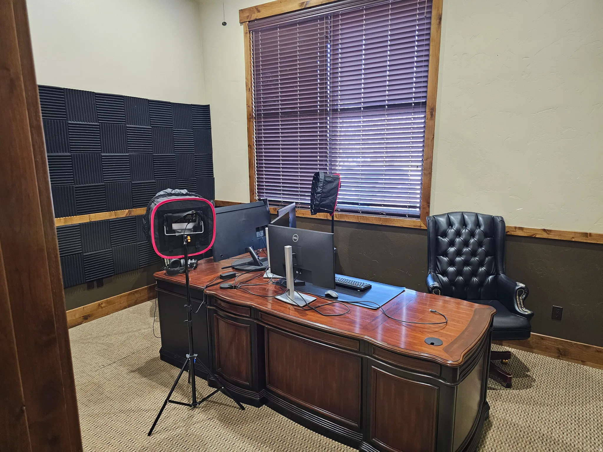 Dedicated office space featuring textured wall panels, wood-finish trim, and a window with horizontal blinds