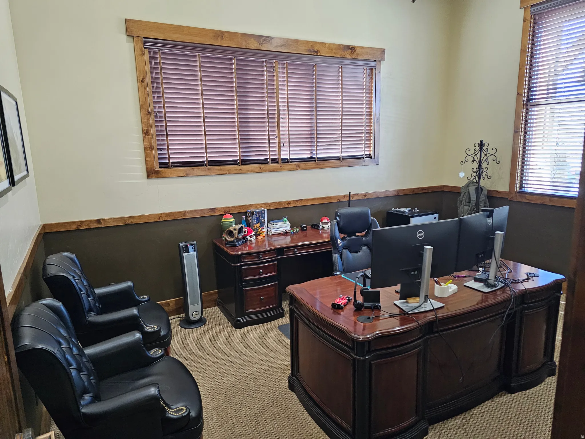 Private office space featuring wood-finish window trim and matching wainscoting