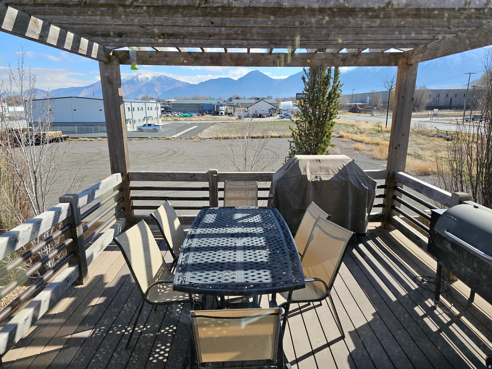 Spacious outdoor deck featuring a wooden pergola and mountain scenery