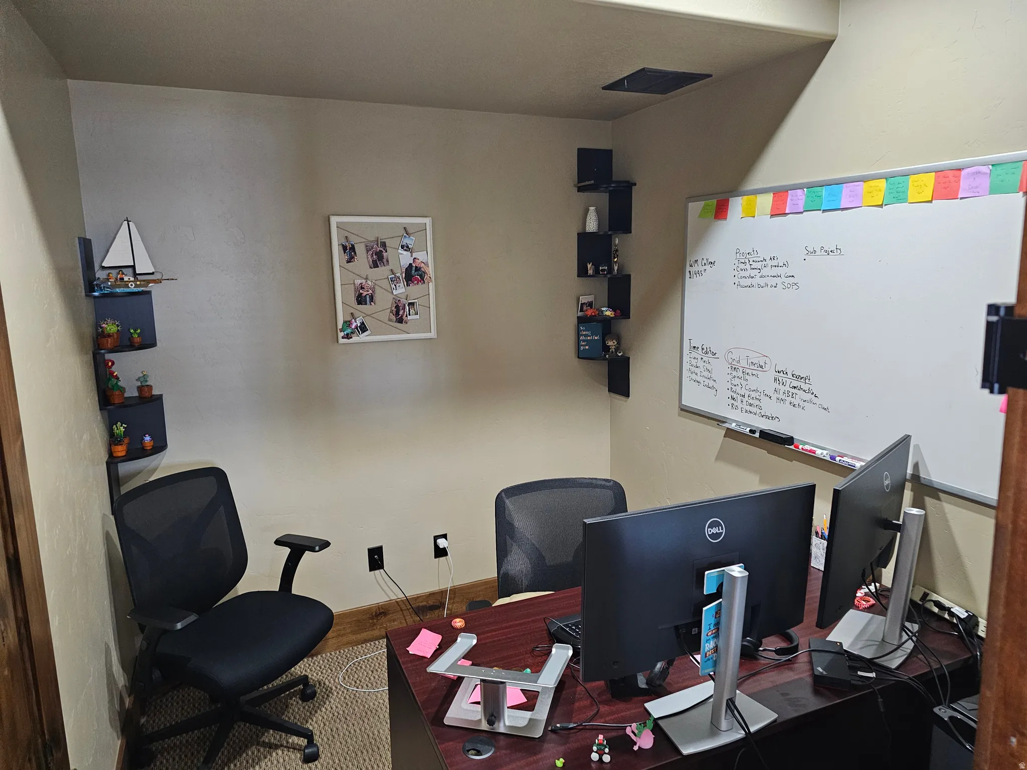 Compact room featuring neutral-toned walls, built-in corner shelving, a built-in whiteboard, and a dark wood-finish desk