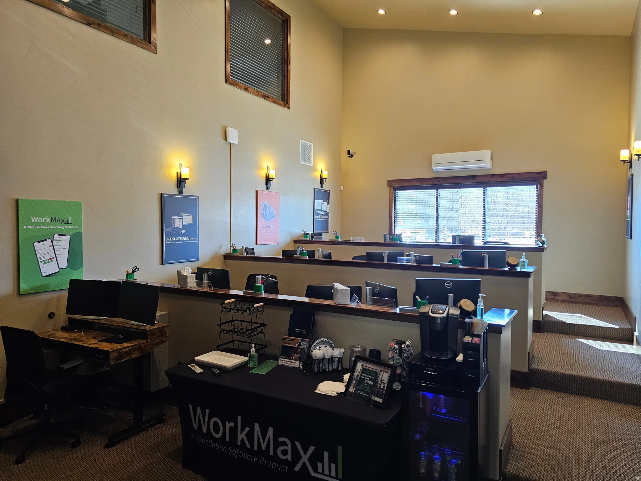 Open-concept commercial space featuring high ceilings, recessed lighting, and wall-mounted sconces