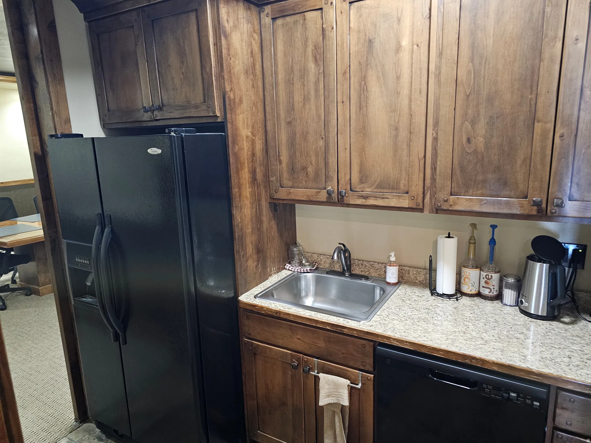 Wood-finish cabinetry and black appliances define this kitchen space