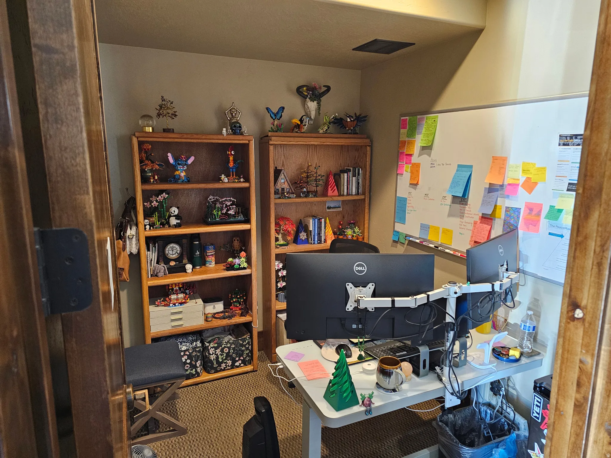 Dedicated office space featuring two built-in wood-finish bookcases, a wall-mounted whiteboard, and neutral wall paint