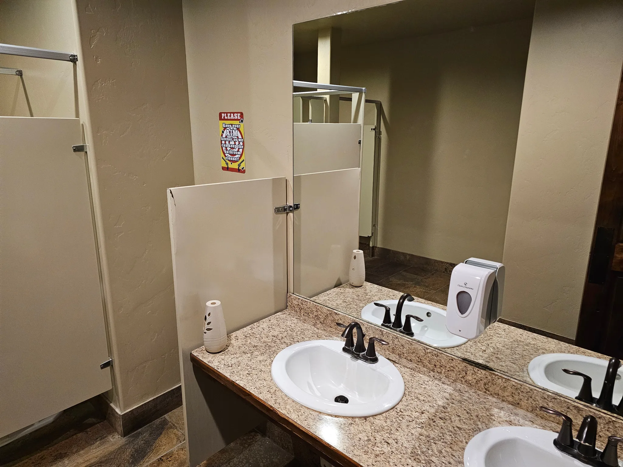 Dual white ceramic sinks with black fixtures set in a speckled countertop