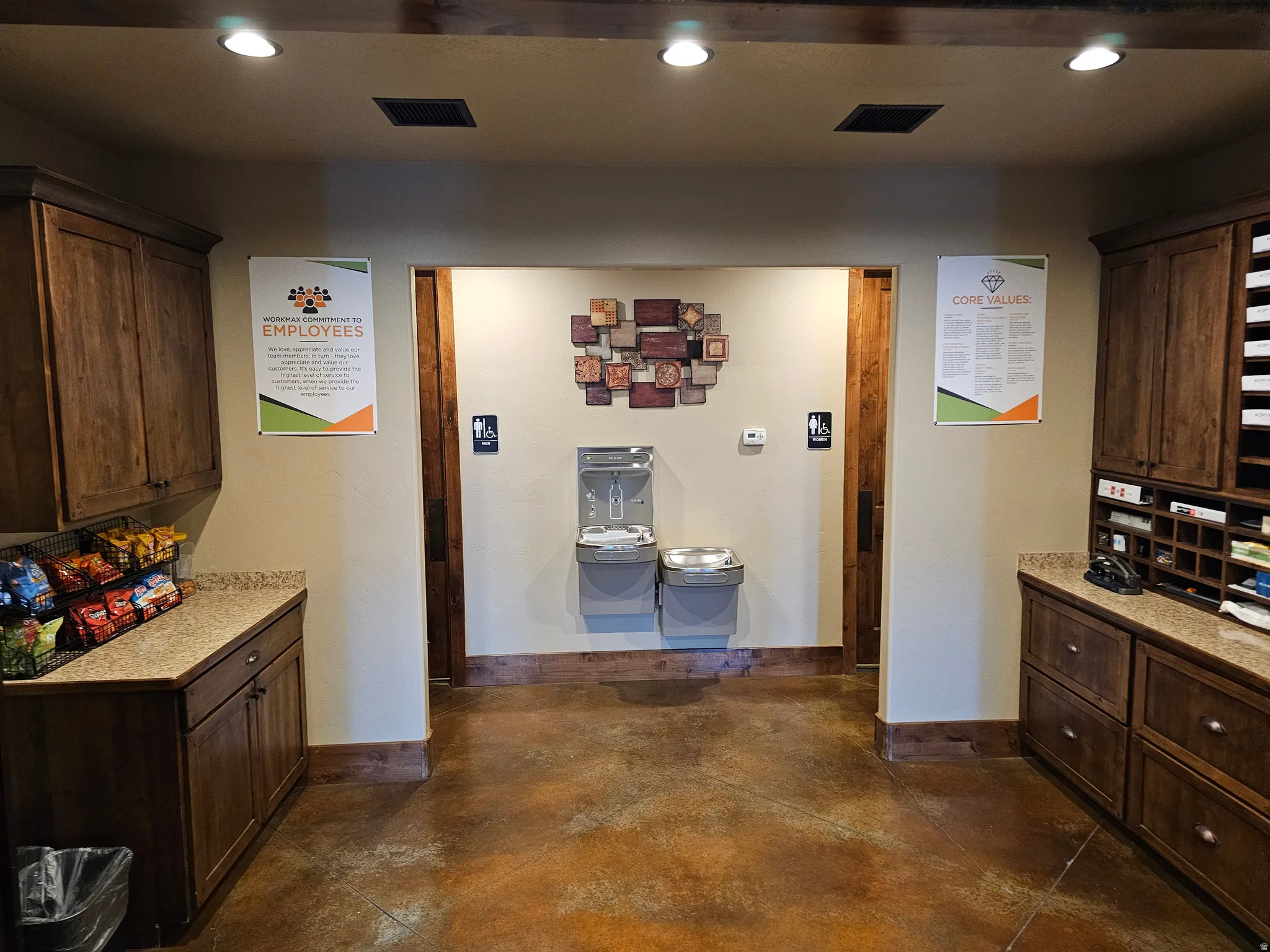 Commercial space featuring warm wood cabinetry, neutral walls, recessed lighting, and a polished concrete floor
