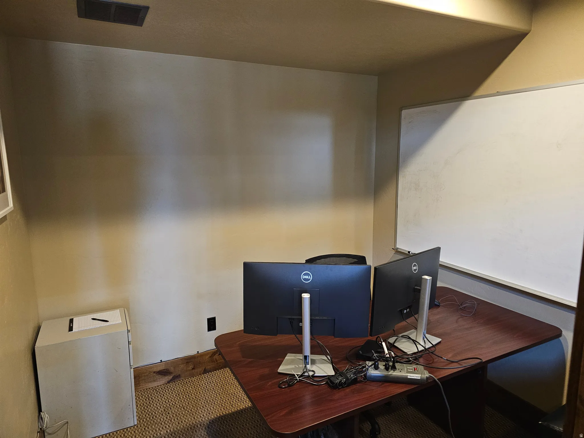 Room featuring wall-to-wall carpeting, neutral wall finishes, and a white board
