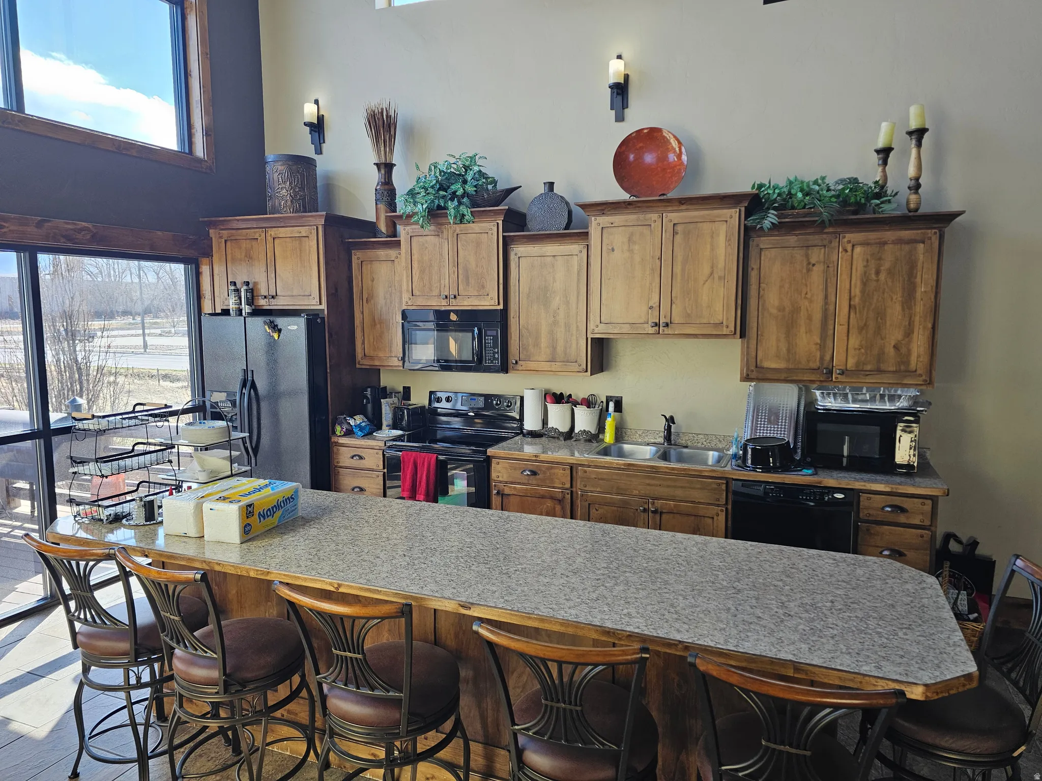 Kitchen featuring wood cabinetry, stainless steel sink, and black appliances