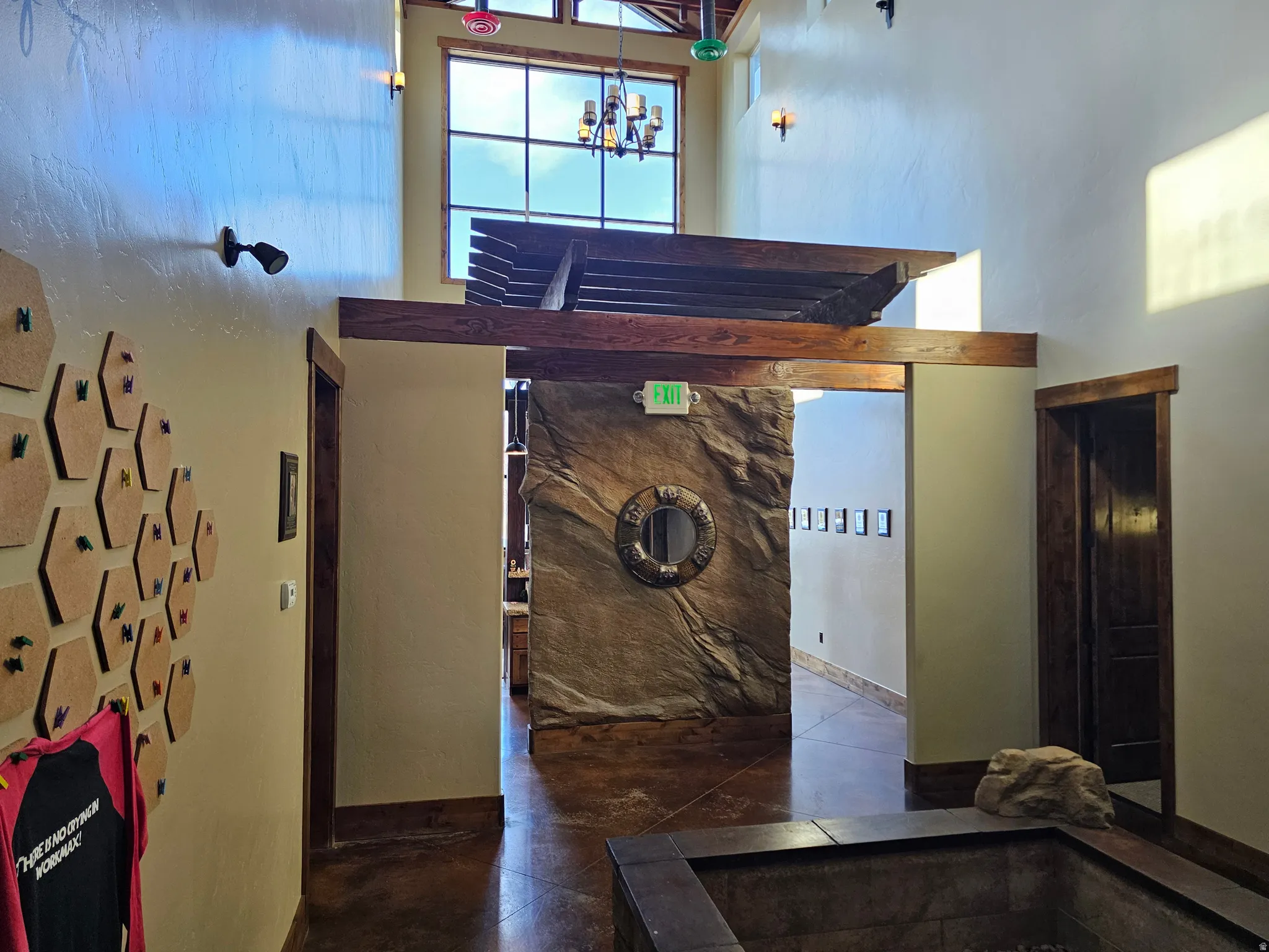 Spacious interior featuring high ceilings, exposed wood beams, and a large upper window