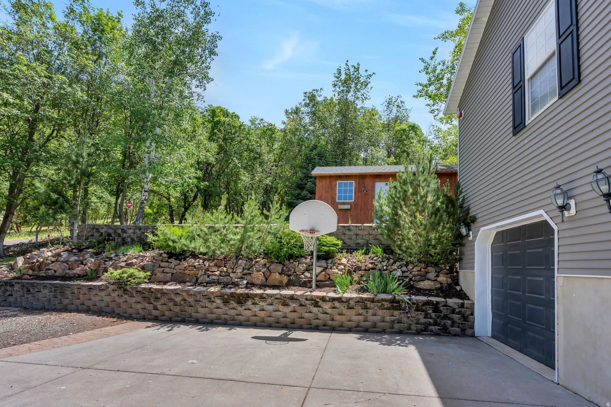Paved driveway leading to a two-car garage with overhead lighting
