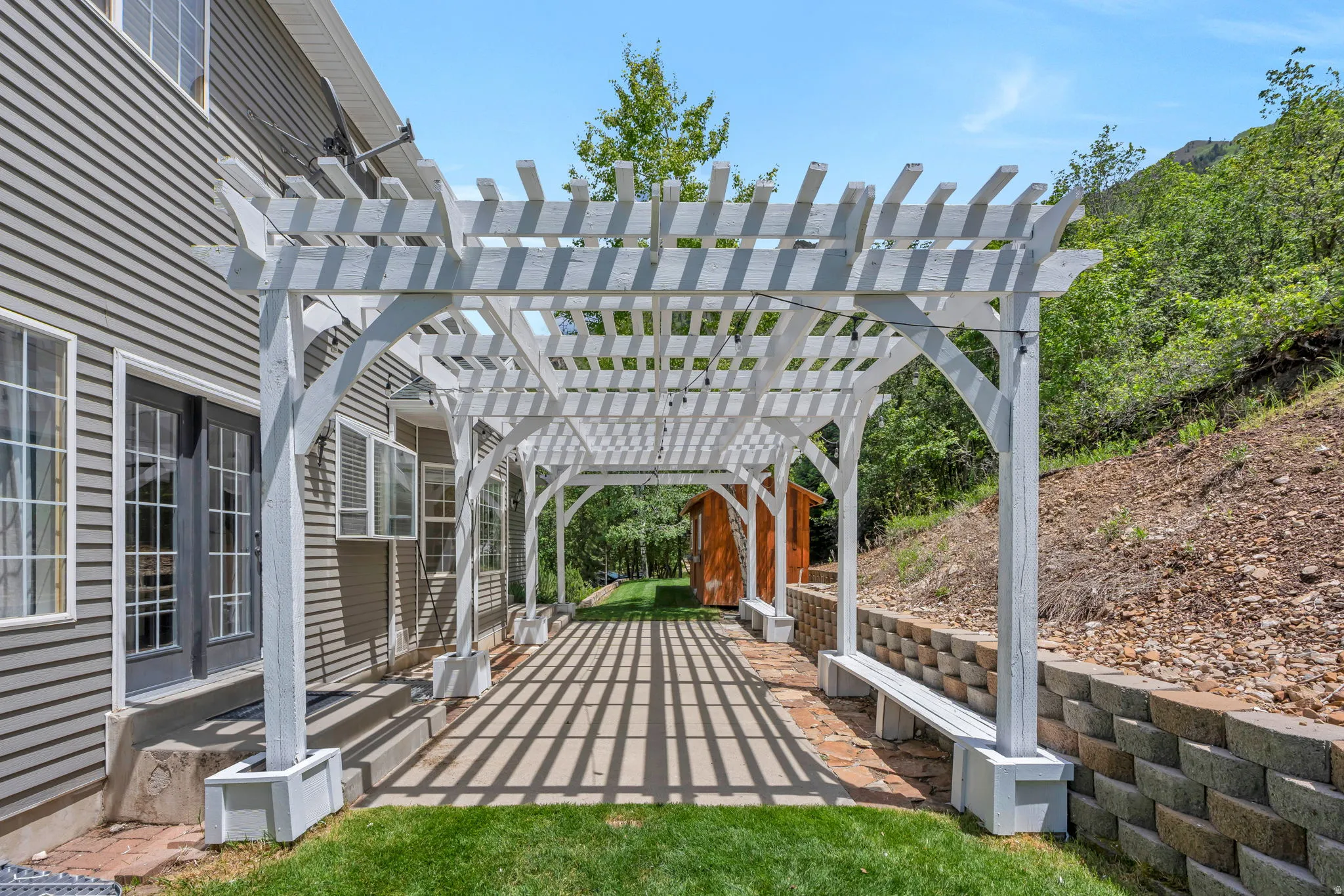Expansive white pergola creating a shaded patio area