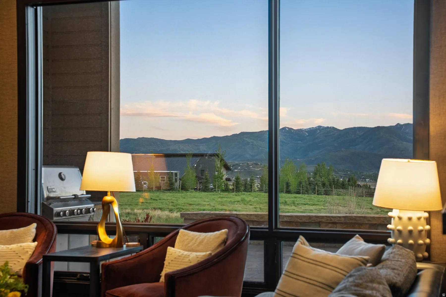 Floor-to-ceiling windows frame expansive mountain and landscape scenery