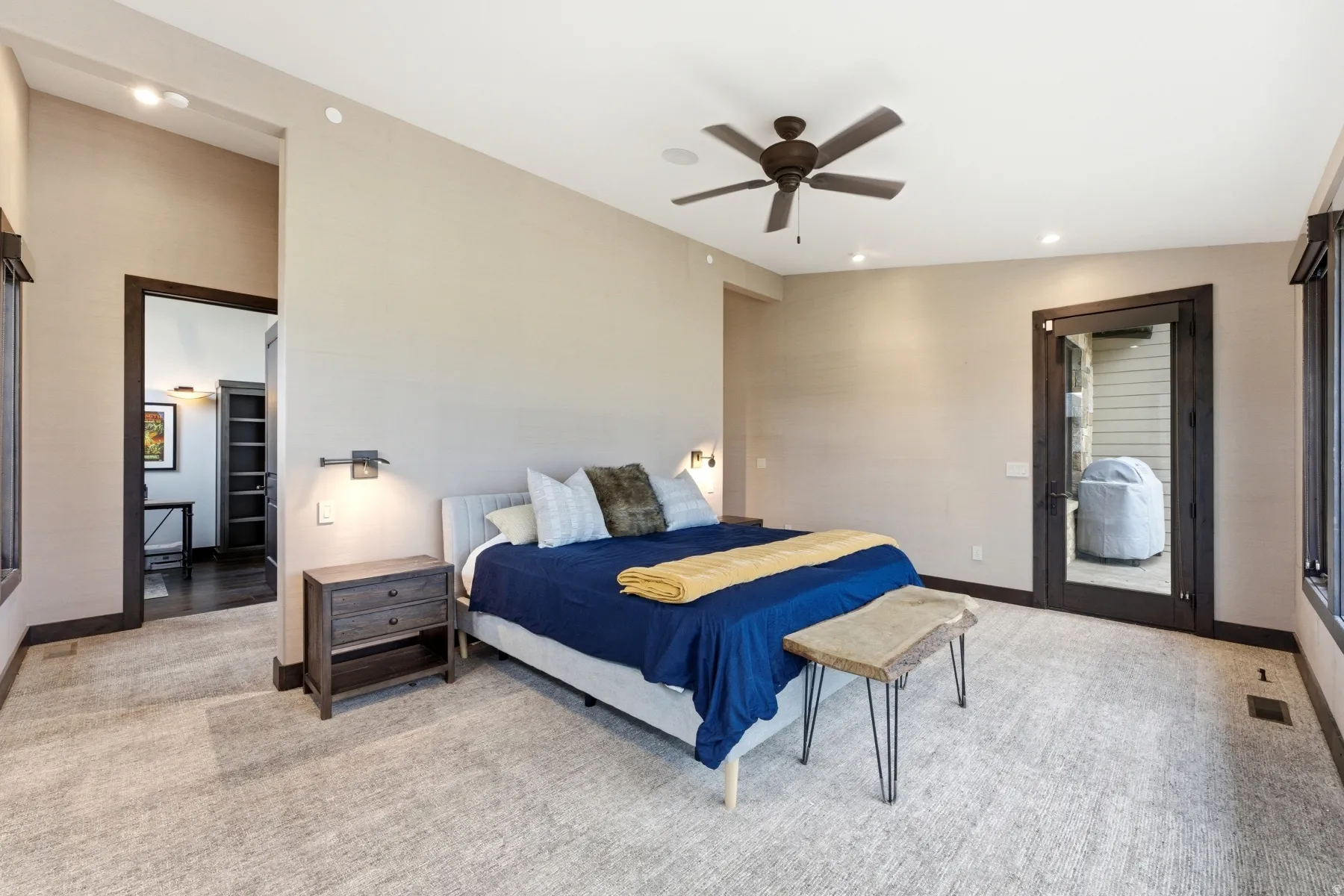 Spacious room featuring neutral carpeting, a ceiling fan, recessed lighting, and a glass-paneled door
