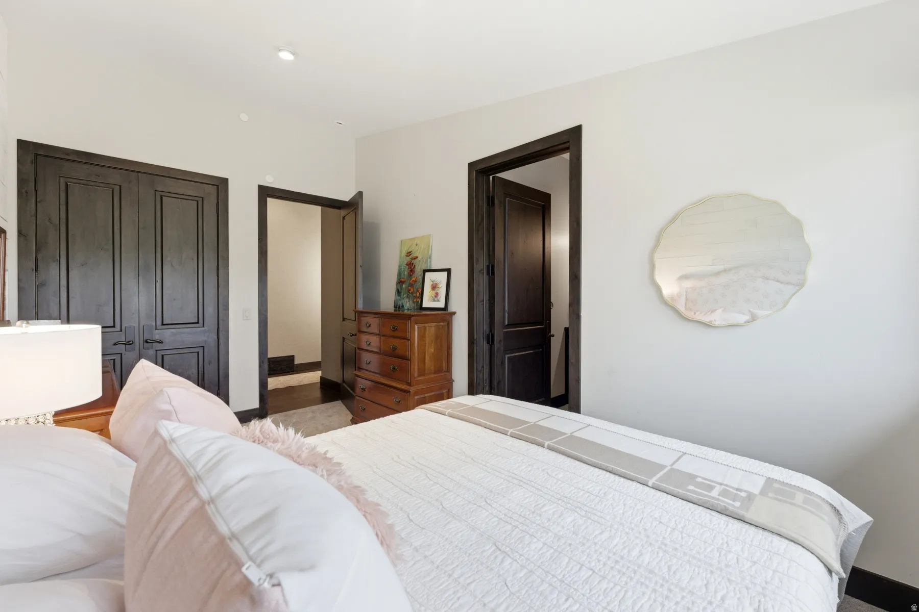 Recessed lighting illuminates a room featuring solid wood paneled double doors and a coordinating solid wood door frame