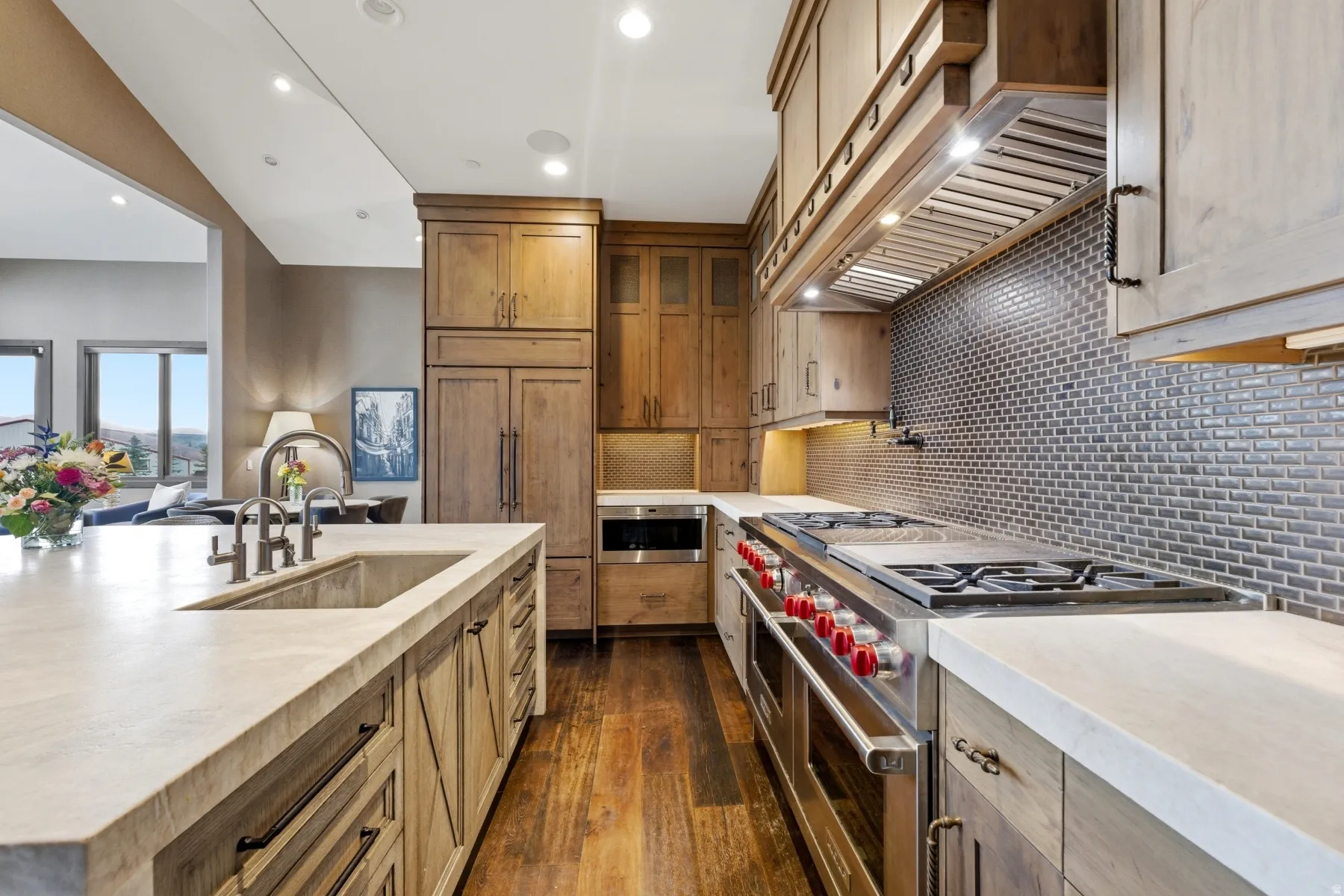 Gourmet kitchen featuring a professional-grade gas range with griddle, stainless steel appliances, a subway tile backsplash, and extensive wood cabinetry