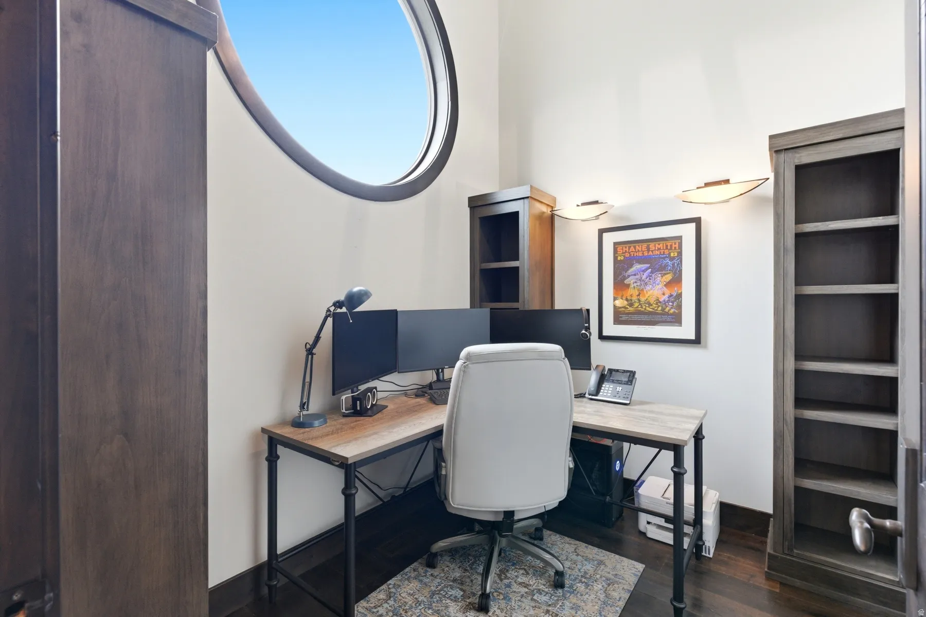 Oval window detail, built-in shelving, wood-finish flooring, and white wall finishes