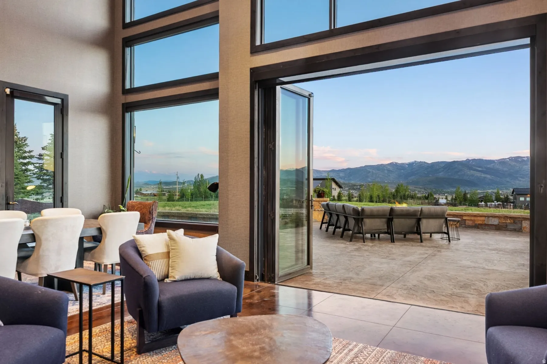 Spacious interior featuring a multi-panel folding glass door system opening to an expansive outdoor patio