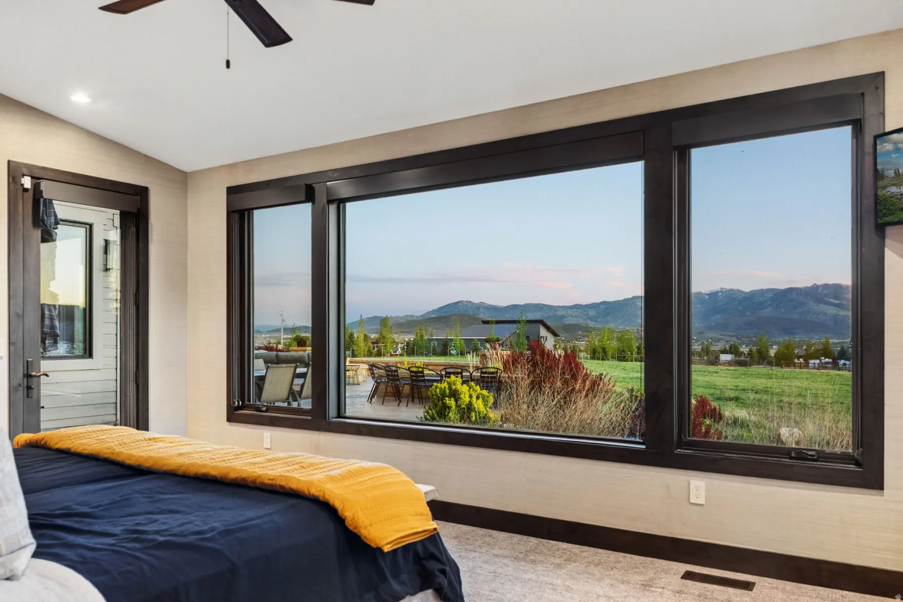 Expansive window array featuring dark wood trim and panoramic mountain scenery