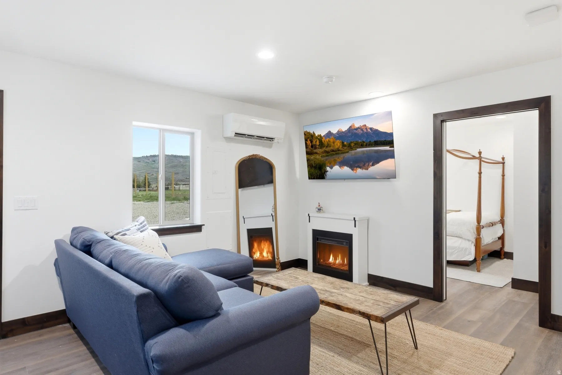 Living area featuring light wood-finish flooring and white walls with dark trim