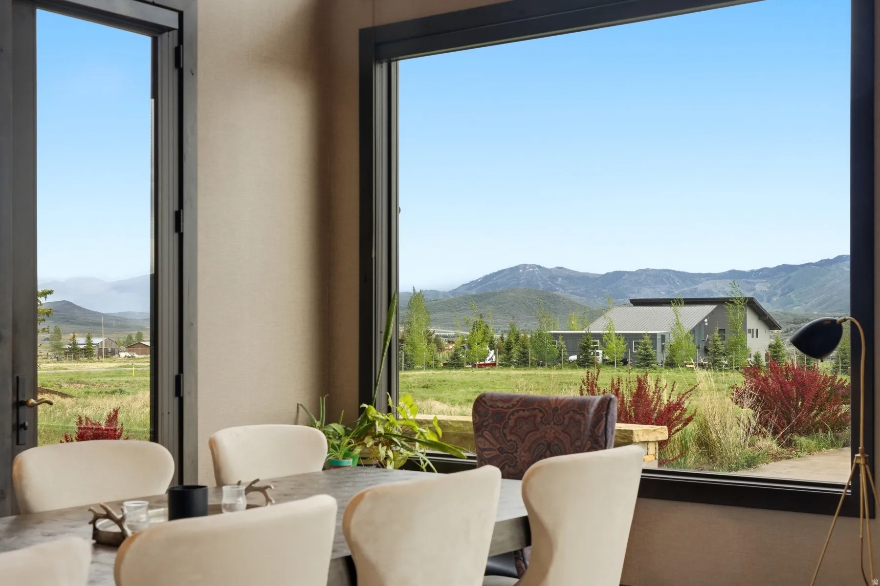 Expansive window framing distant mountains and green landscape