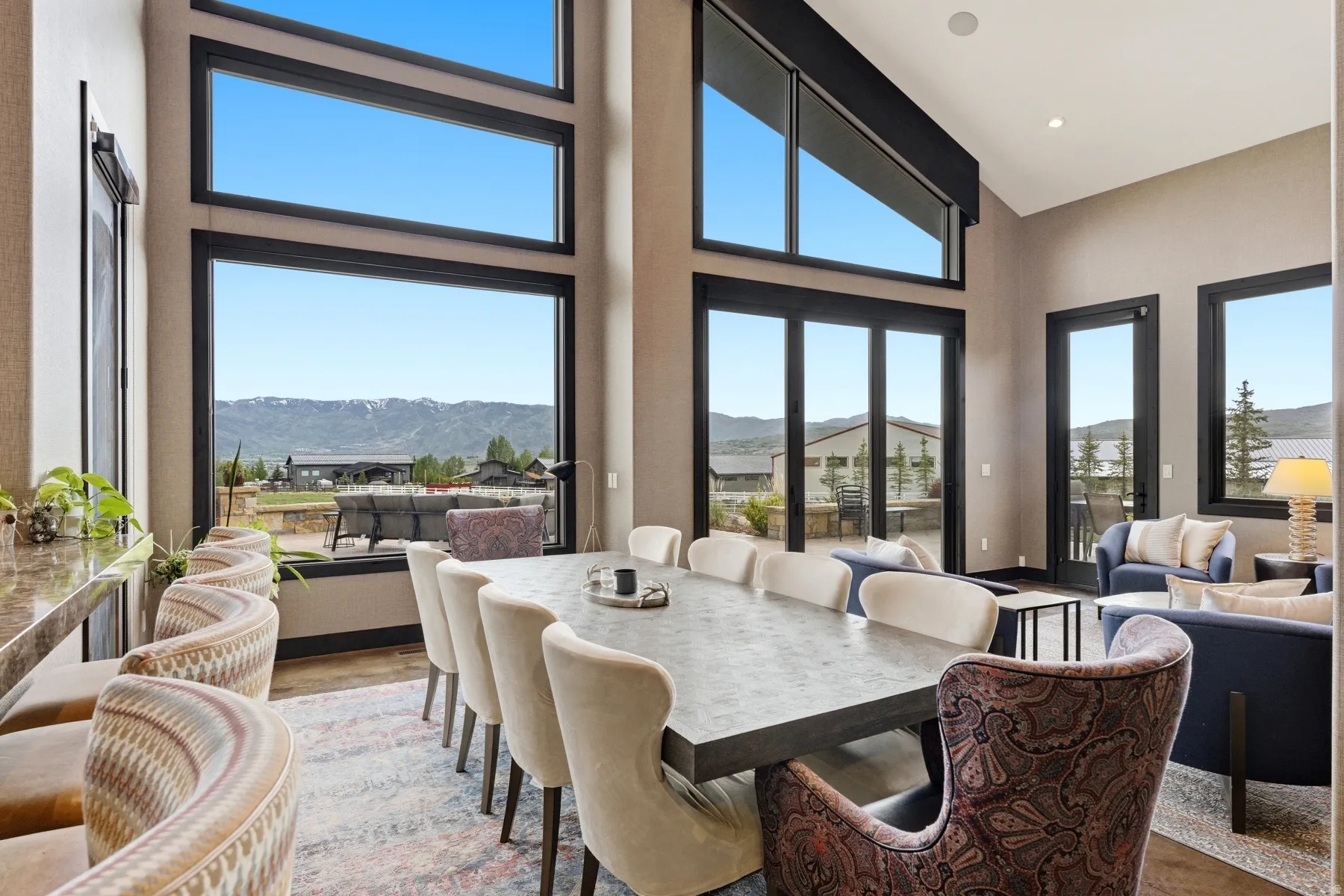 Dining area featuring vaulted ceilings, floor-to-ceiling windows, and a large dining table