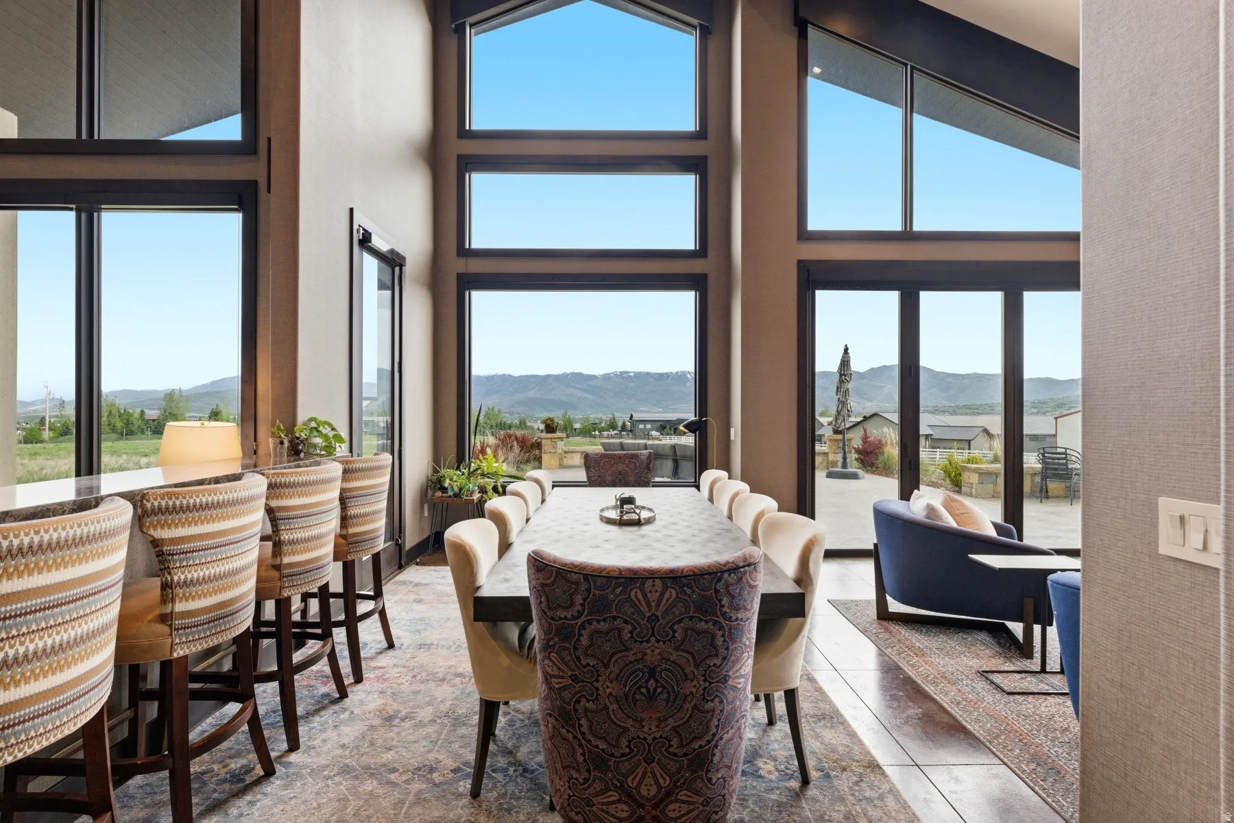 Expansive great room featuring a tall vaulted ceiling, a wall of floor-to-ceiling windows, and wood-finish flooring
