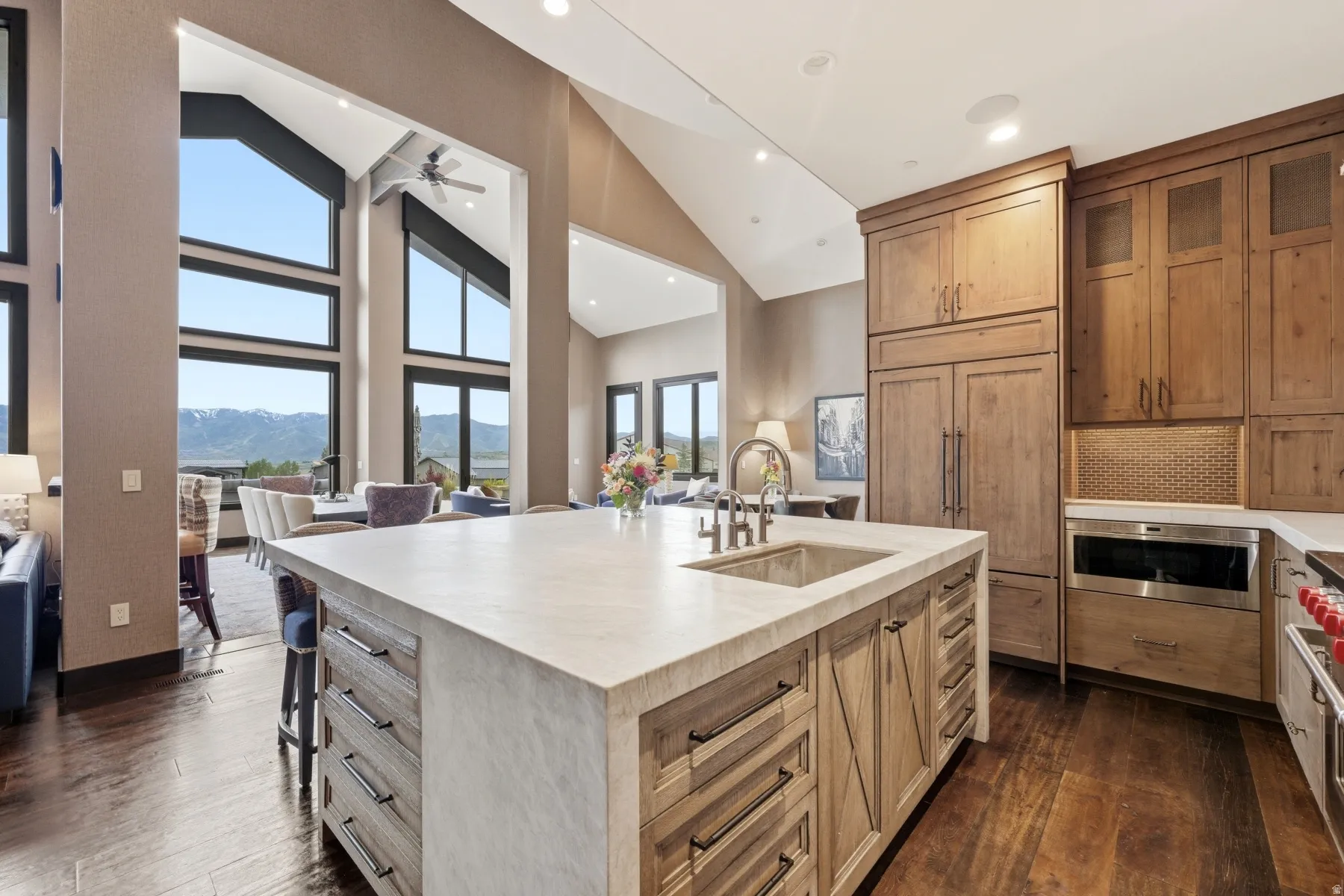 Kitchen island with integrated sink and chrome faucet, featuring a light-toned countertop and wood-finish cabinetry