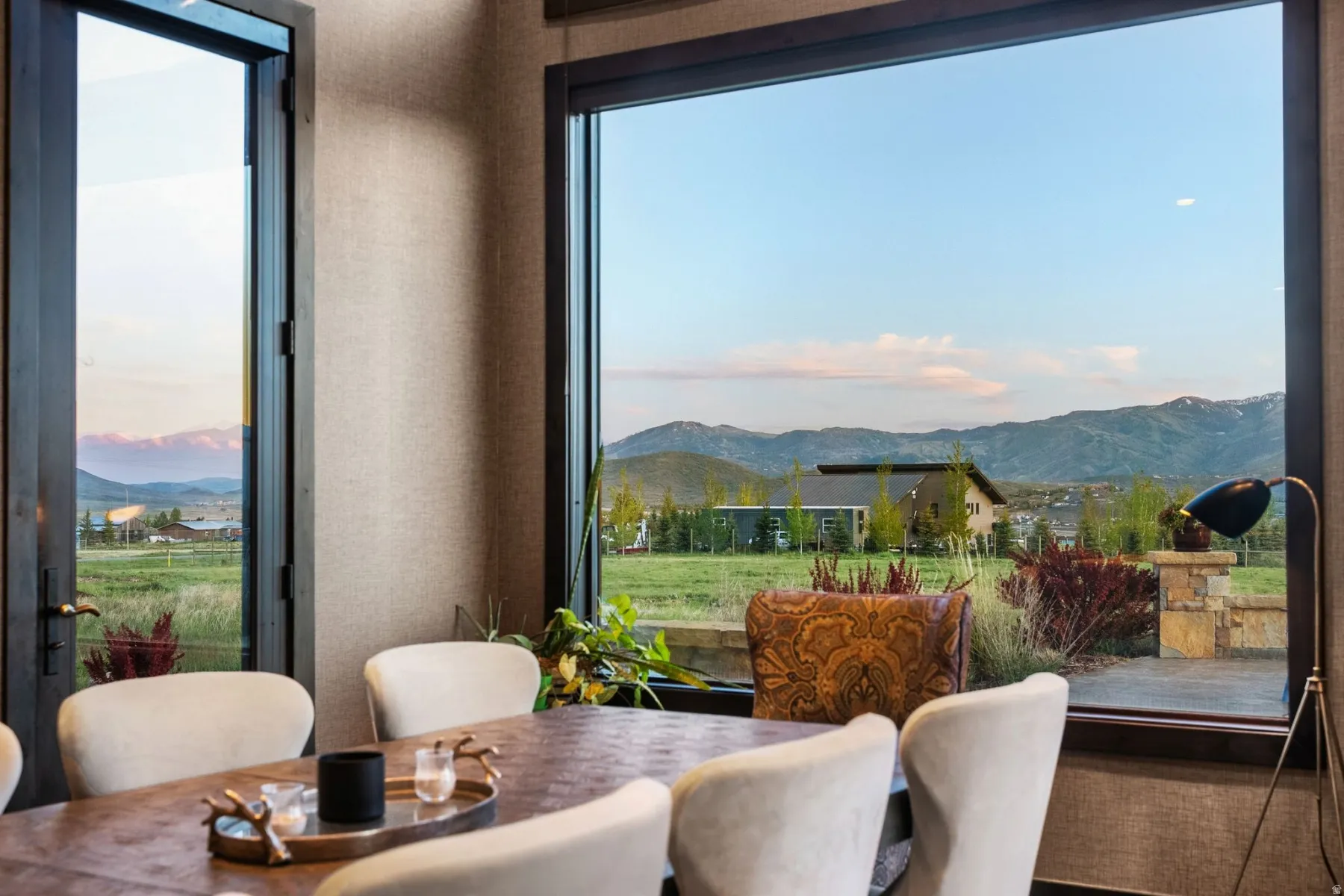 Spacious interior featuring large picture windows and a glass-paned door, offering expansive mountain scenery