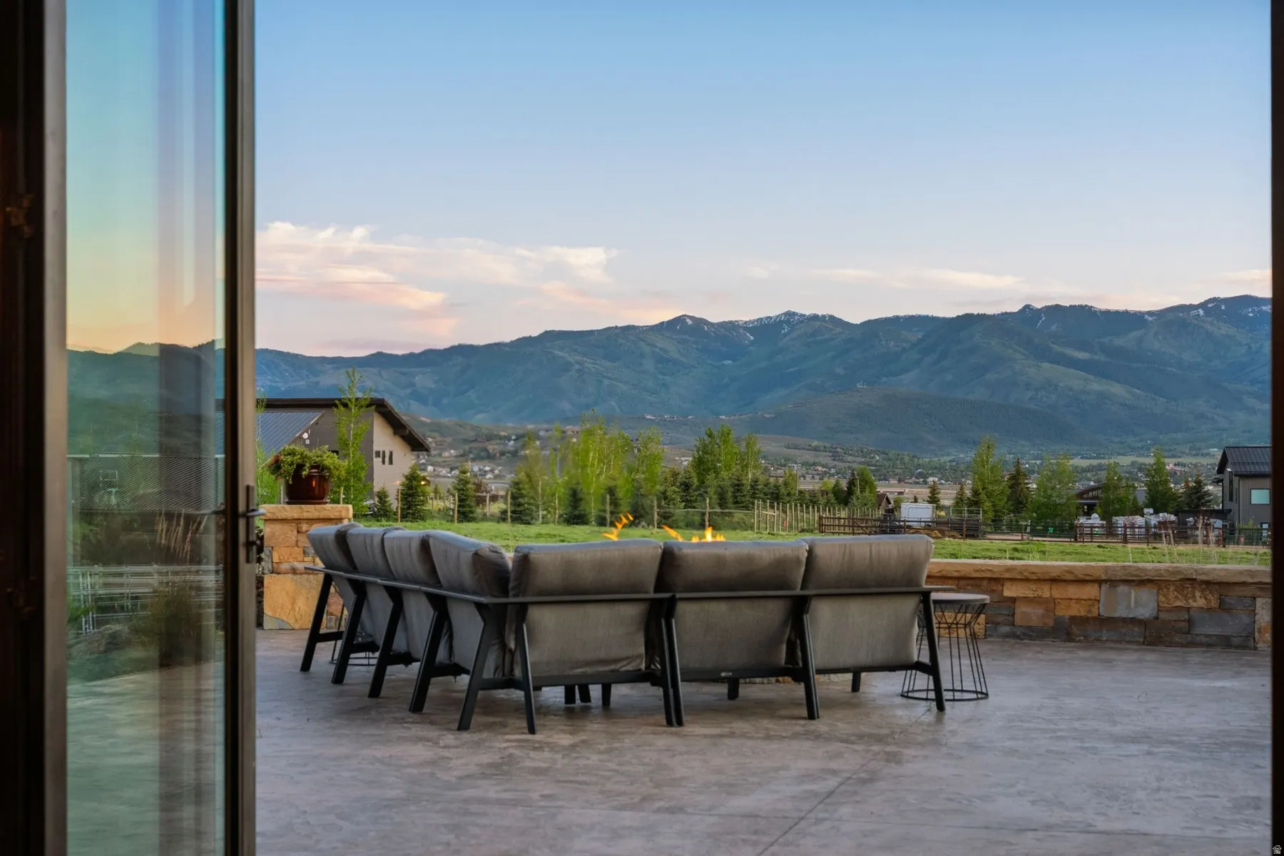 Expansive outdoor patio with stamped concrete flooring and a stone retaining wall