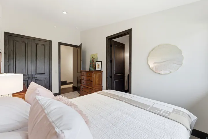 Recessed lighting illuminates a room featuring solid wood paneled double doors and a coordinating solid wood door frame