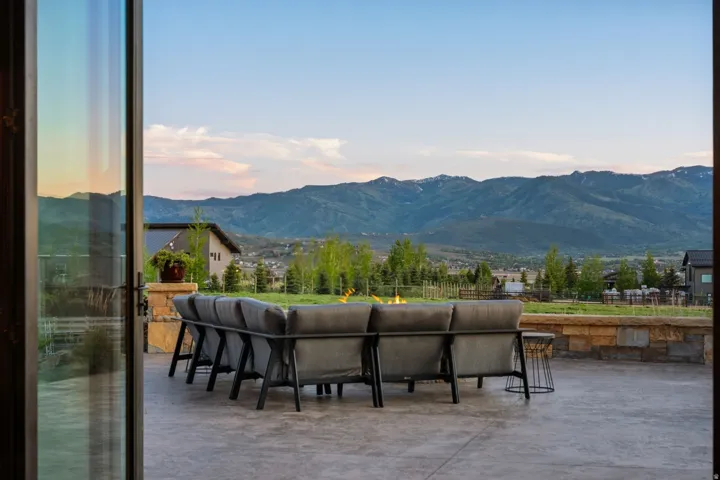 Expansive outdoor patio with stamped concrete flooring and a stone retaining wall