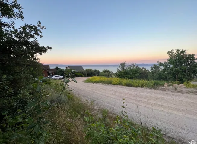 Gravel road with natural landscaping and distant water