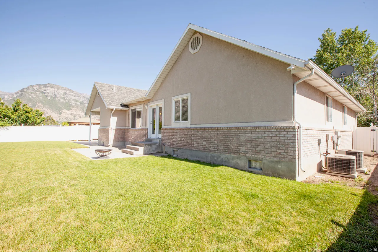 Expansive grassy yard with a concrete patio