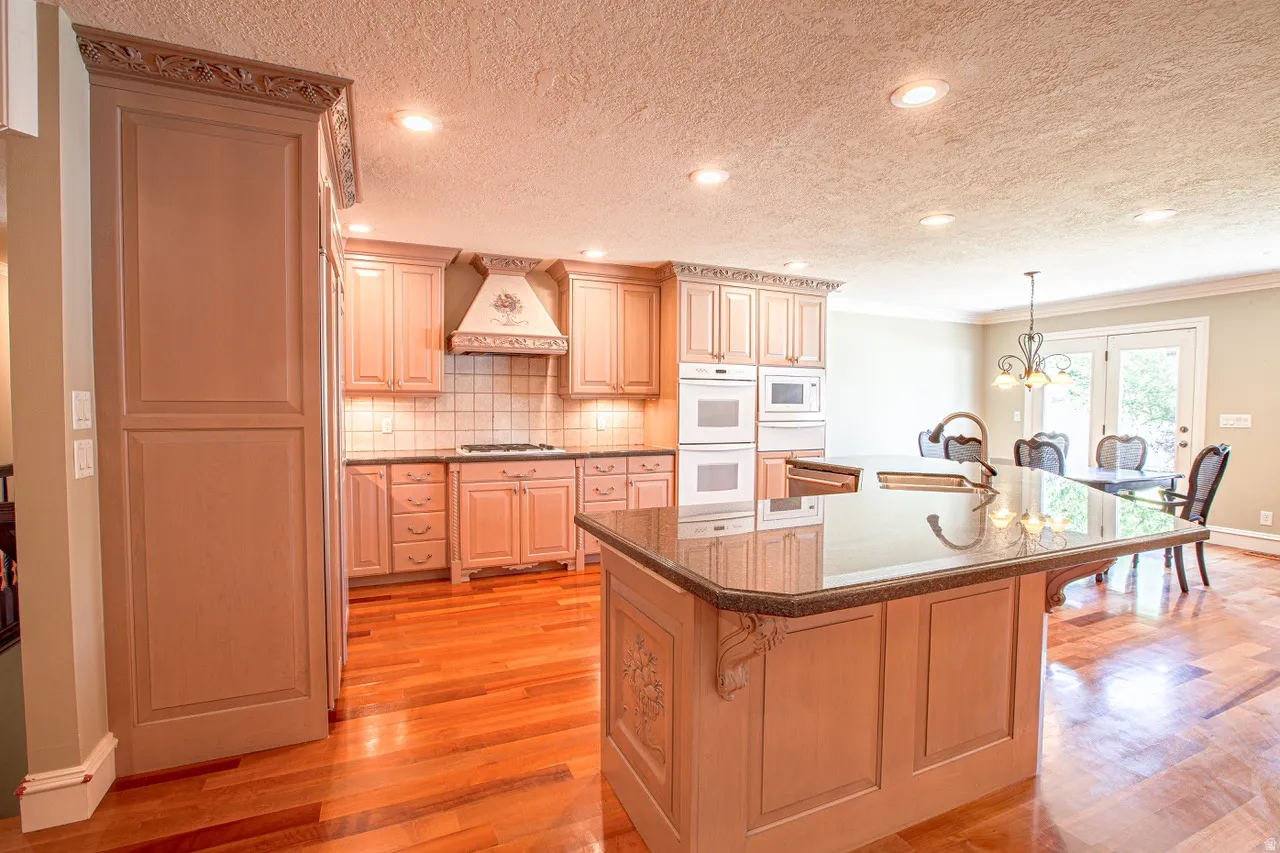 Kitchen featuring wood-finish flooring, recessed lighting, and a kitchen island with a dark countertop