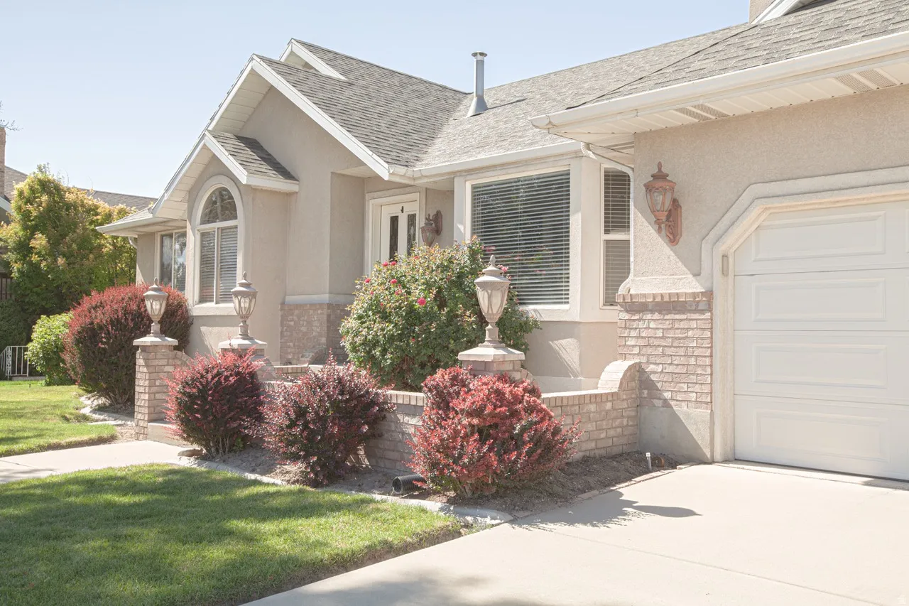 Front exterior featuring a cream stucco finish and brick accents