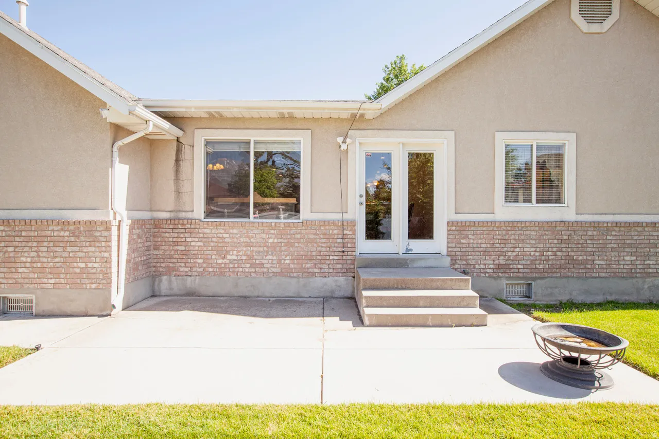 Concrete patio featuring a two-step entry to double glass doors