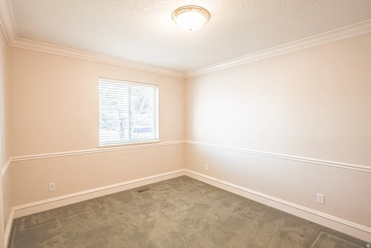 Neutral-toned room featuring a single window with horizontal blinds