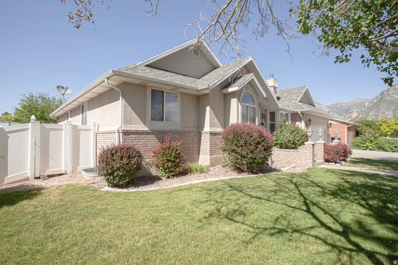 Exterior architecture with brick detailing, stucco finish, and a gabled roofline