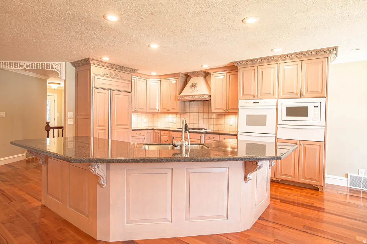 Kitchen featuring a large central island with a dark countertop and an undermount sink