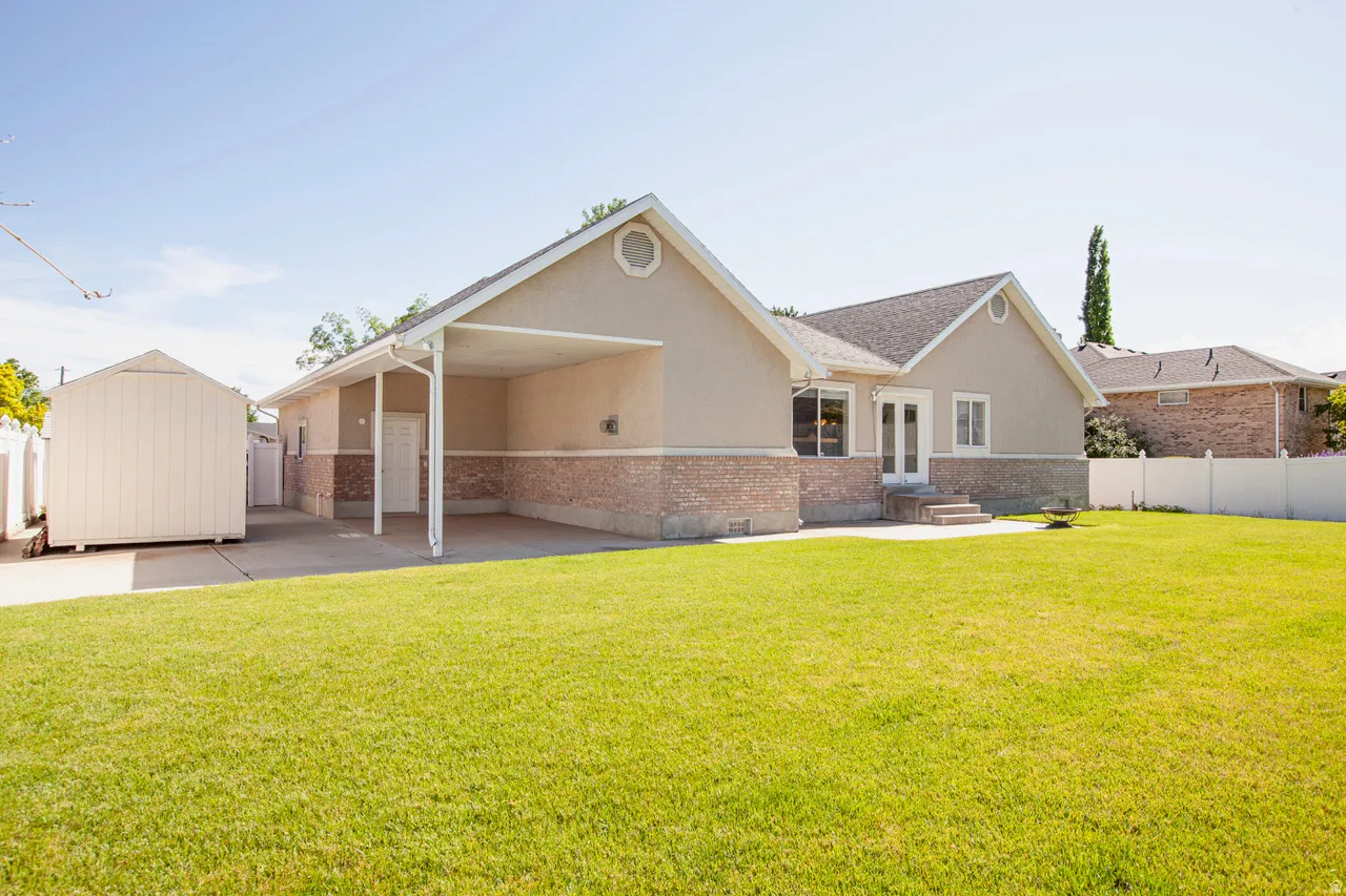 Spacious rear yard with a manicured lawn, complemented by a stucco and stone-veneer exterior