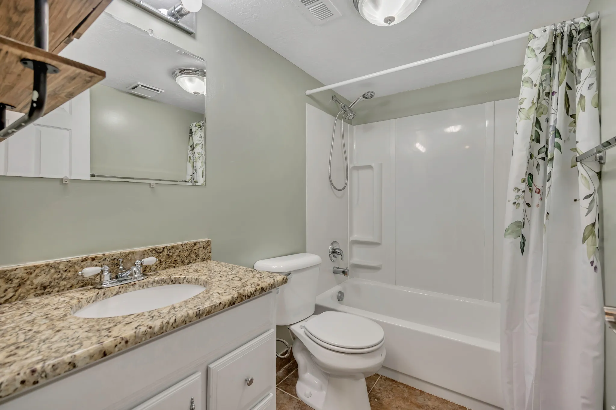 Bathroom with a white vanity featuring a granite countertop and an undermount sink
