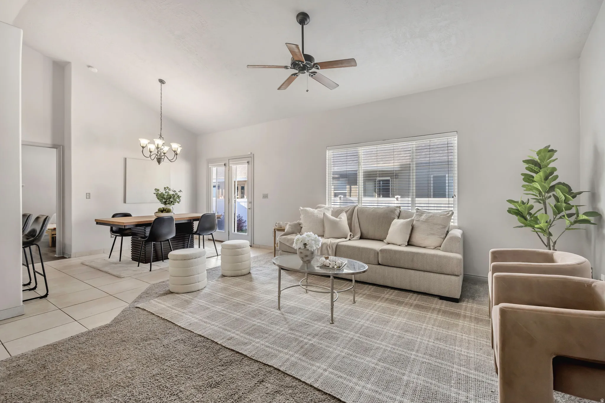 Bright living area with vaulted ceilings and a ceiling fan