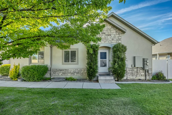 Stone veneer and stucco exterior with an arched entryway